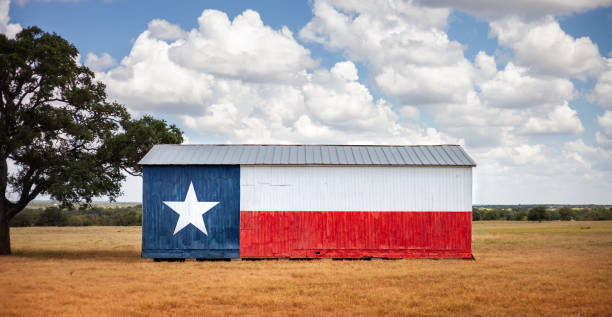 Texas flag painted on old barn. American farmers background, rural scene. stock photo