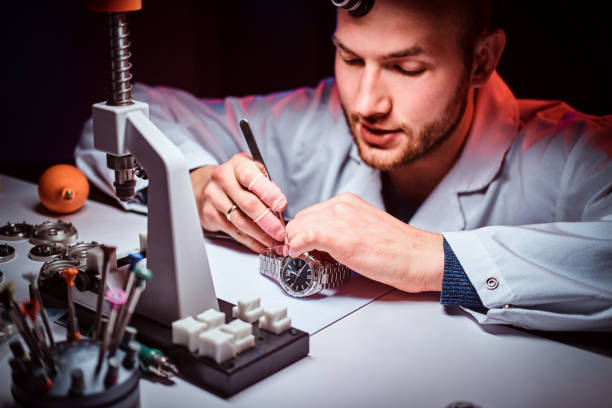 istock Expirienced watchmaker is doing engraving for custmer's watch at his workshop 1185679286