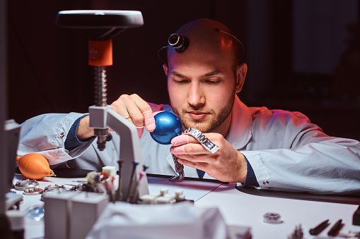 Smart watchmaker is restoring cutomer's watch at his own repairing studio.