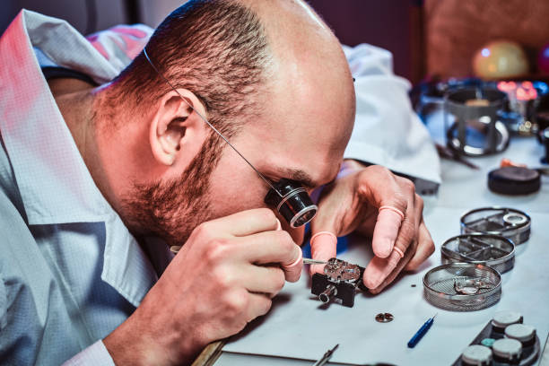 istock Expirienced clockmaster is fixing old watch for a customer at his repairing workshop 1185679511