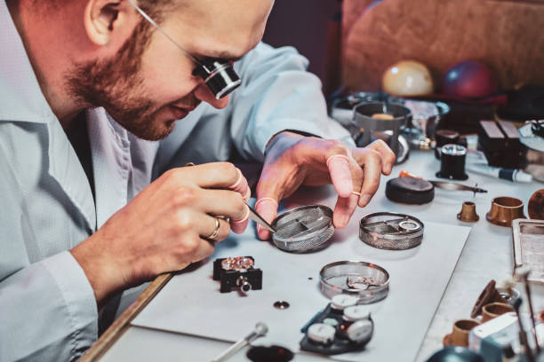 istock Expirienced clockmaster is fixing old watch for a customer at his repairing workshop 1185679599