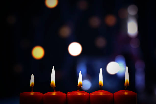 istock Burning red candles with blurred Christmas light 1185680005