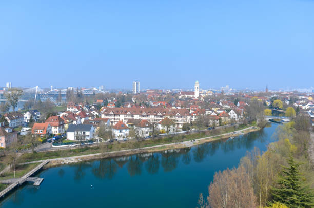 European cityscape on a river with reflections of trees along the waterfront greenbelt area on the water in an elevated view of the skyline