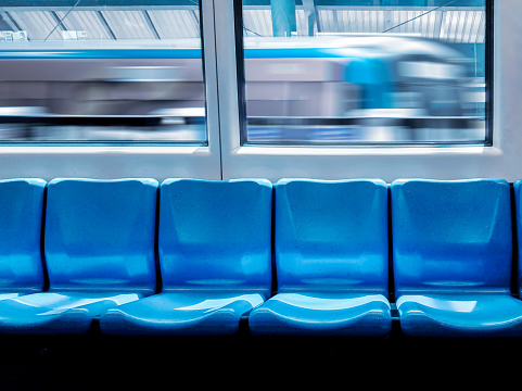 Train station and empty seats commuter with blue color interior inside in the subway train.