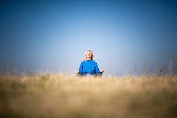 Senior woman meditating in nature.