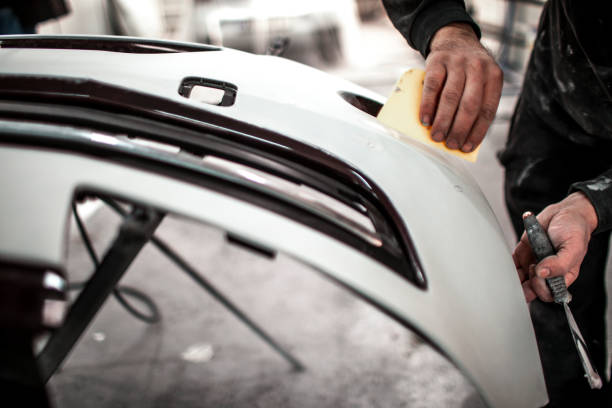 istock Shaping and repairing a car part using a sand paper 1185695701