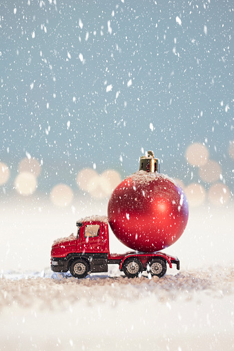 isolated figurine of a red truck with a red christmas ball on a white background