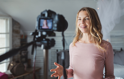 Happy female vlogger live streaming from living room