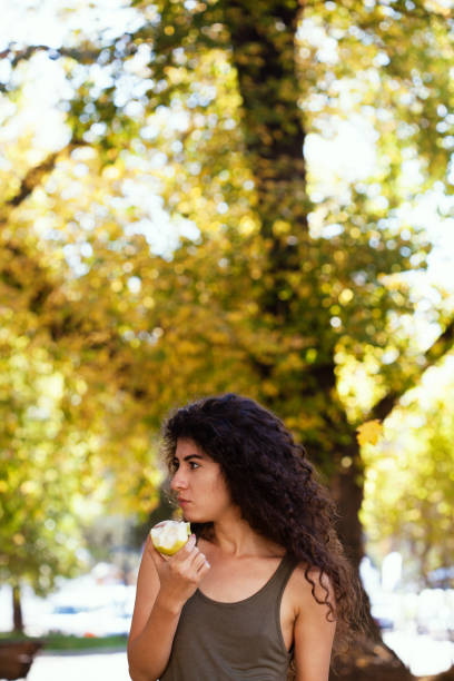 istock Young woman eating an apple 1185698926