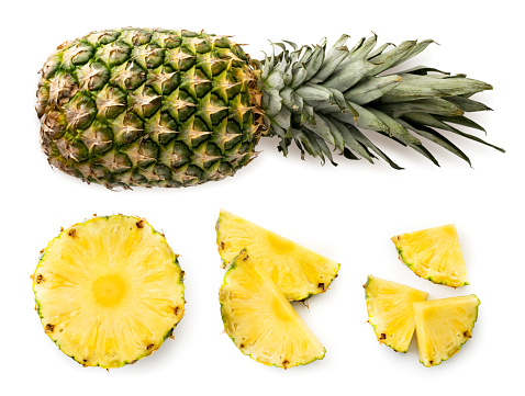 Ripe pineapple, half and clippers set on a white background. The view of the top.