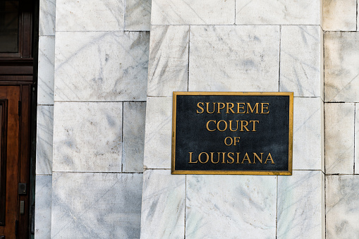 New Orleans, USA - April 23, 2018: Old town Royal street in Louisiana famous town city with exterior closeup of sign for entrance to Supreme Court building