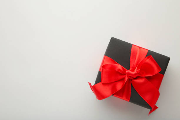 istock Black gift box with red ribbon and bow on grey background. 1185710146