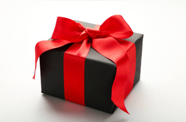 istock Black gift box with red ribbon and bow on grey background. 1185710161