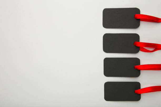 Blank black paper label on textured striped fabric. Photo with copy blank space.