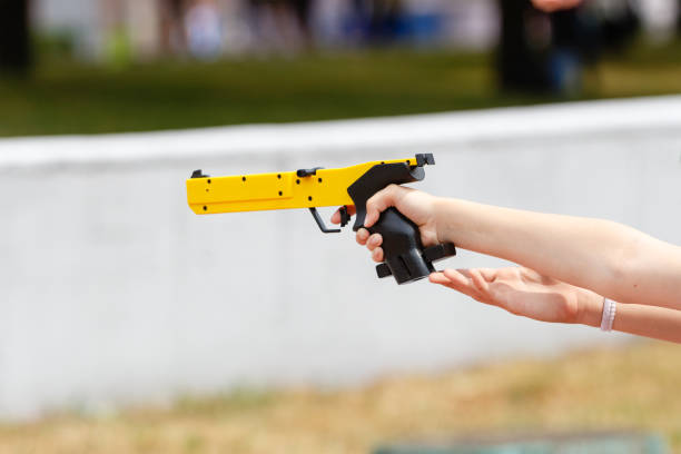Hand with a yellow laser sport gun closeup Hand with a yellow laser sport gun closeup view with blurred background pentathlon stock pictures, royalty-free photos & images