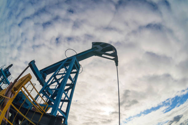 pompe à huile sur le fond du ciel bleu et du soleil de matin, l'éblouissser de soleil sur la pompe à huile - oil pump flash photos et images de collection