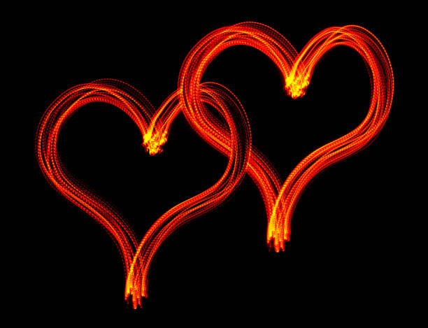 istock Glowing intertwined hearts - LED light painting (red) 1185714077