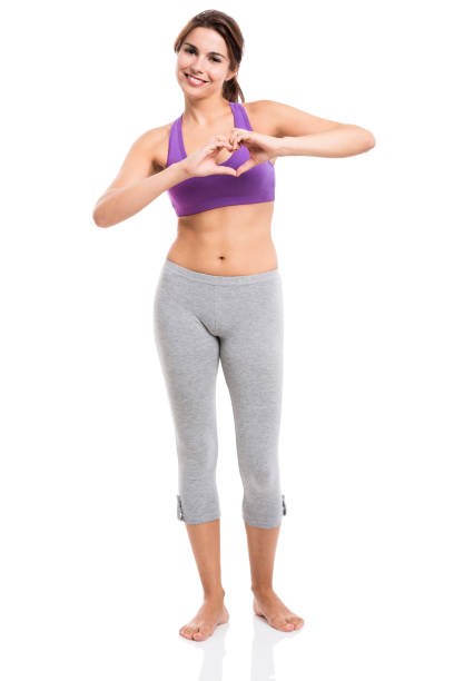 Beautiful and healthy woman making a hearth with her hands, isolated over white background