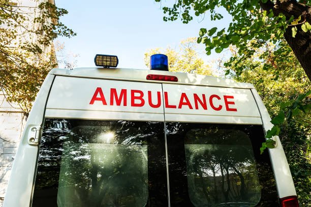 Stationary white ambulance car with a blue warning light on a roof. An emergency medical service van. On a sunny autumn day. stock photo