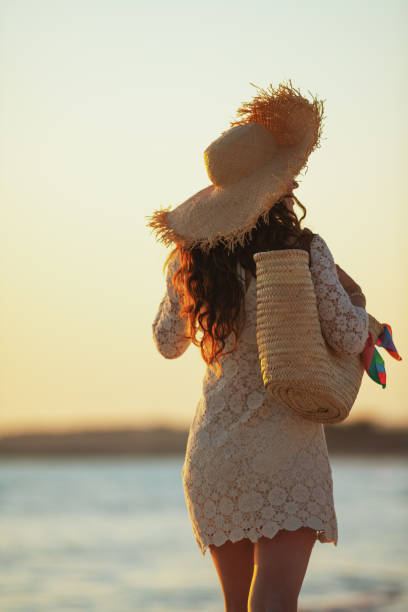 istock modern woman on ocean coast at sunset walking 1185725829