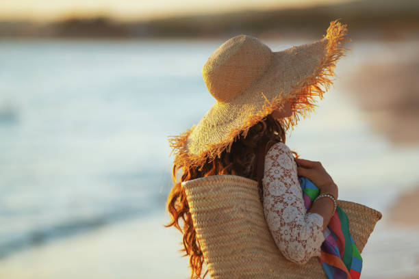 istock young woman on beach at sunset walking 1185725871