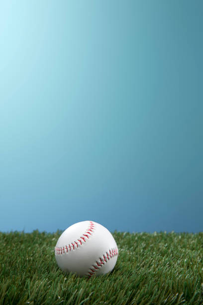 istock Baseball on Green Grass with Blue Sky Background 1185725950