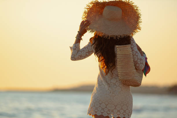 stylish woman on beach at sunset walking