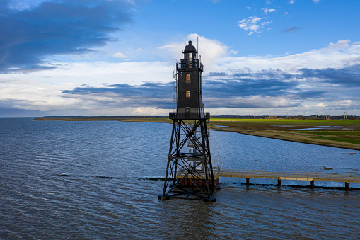 Beautiful Obereversand lighthouse or Leuchtturm of North Sea near Bremen, Bremerhaven and Weser river in the dusk. Dorum-Neufeld, Wurster Nordseekuste, Germany. Lower Saxon Wadden Sea National park.