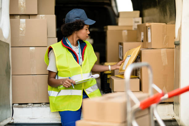 istock Female African American deliverer sorting packages in a van. 1185729930