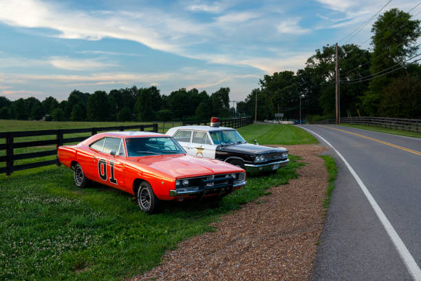 Replicas of the General Lee Charger and the Sheriff car, from the television series The Dukes of Hazzard, parked along a country road Tennessee, USA - June 26, 2014: Replicas of the General Lee Charger and the Sheriff car, from the television series The Dukes of Hazzard, parked along a country road in the State of Tennessee. the general lee stock pictures, royalty-free photos & images