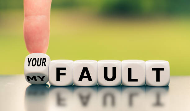 Hand turns a dice and changes the expression "my fault" to "your fault", or vice versa. stock photo