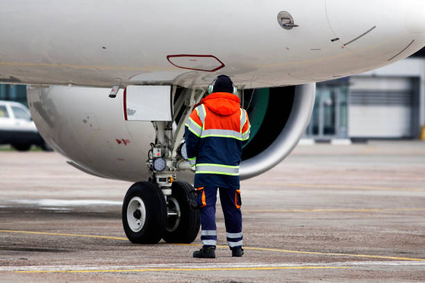 A ground control manager helps to park the aircraft stock photo