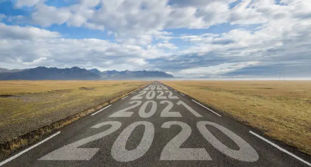 A long straight street in iceland on which the individual years of the next years are painted. starting from the year 2020 until the year 2023