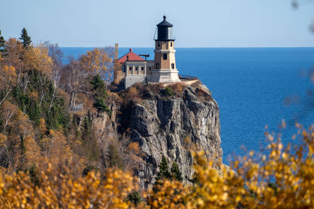 encuadre natural del faro de split rock en la costa norte de minnesota, enmarcado por hojas de otoño - split rock lighthouse fotografías e imágenes de stock