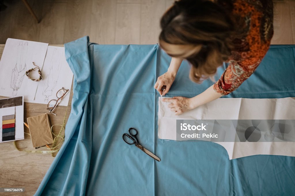Making a few minor adjustments Unrecognizable  fashion designer cutting fabric in her design workshop, directly above Sewing Stock Photo