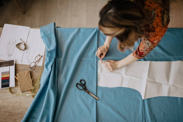 Making a few minor adjustments Unrecognizable  fashion designer cutting fabric in her design workshop, directly above clothing pattern stock pictures, royalty-free photos & images