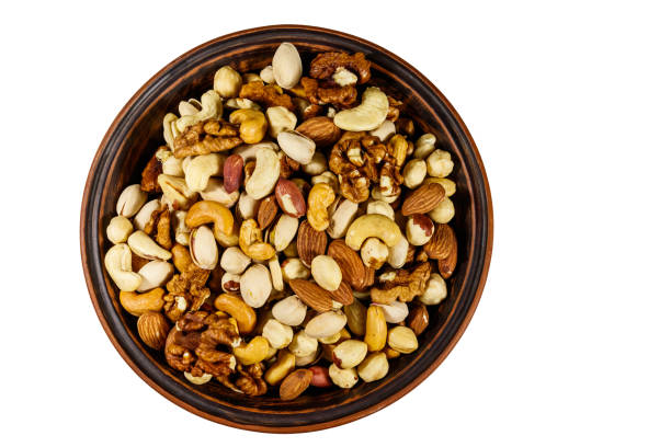 istock Bowl with mixed nuts isolated on white background. Walnuts, pistachio, almond, peanut, cashew, hazelnut in ceramic bowl. Top view 1185736332