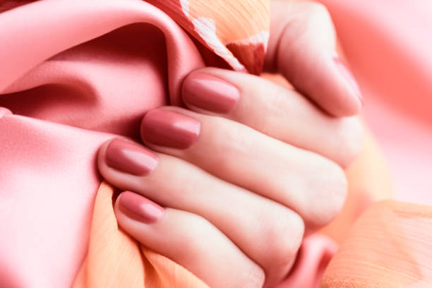 istock Female hand with peach colored manicure 1185736358