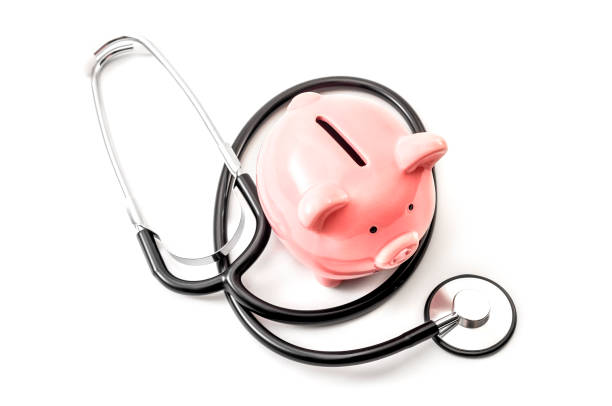 costo dell'assistenza sanitaria e l'alto prezzo del concetto di assicurazione sanitaria di qualità con uno stetoscopio e un salvadanaio rosa isolato su sfondo bianco - currency stethoscope healthcare and medicine savings foto e immagini stock