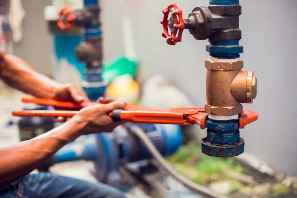 encanador usando uma chave inglesa para reparar e remover a tubulação e a válvula da fonte de água. - valve water pipe leaking faucet - fotografias e filmes do acervo