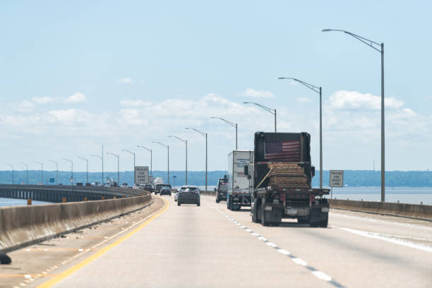 Highway interstate 10 bridge road traffic with trucks Mobile, USA - April 24, 2018: Alabama city with long highway interstate 10 bridge road traffic with trucks through bay and river mobile bay stock pictures, royalty-free photos & images