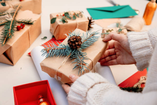 istock Woman wrapping a gift for a Christmas on a table 1185751027