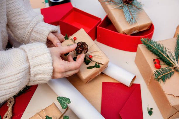 istock Woman wrapping a gift for a Christmas on a table 1185751067