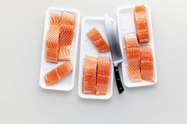 istock fresh salmon, cut into pieces and ready for cooking. fish cutting,  and a big chef knife. plastic box 1185752102