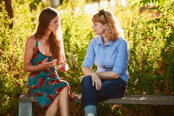 istock Female friends talking on a park bench 1185754199