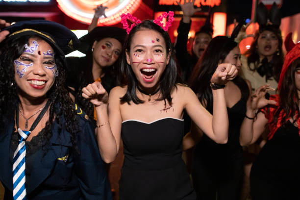 amiche asiatiche in costume di halloween che camminano e si diffondono sulla strada notturna - dacing foto e immagini stock