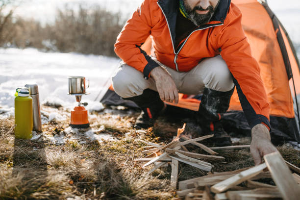 istock Man camping in mountain range on snowy winter day 1185757791
