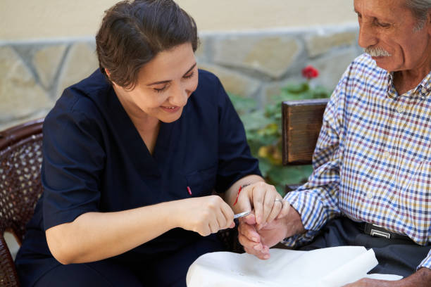 istock Professional helpful caregiver and a senior man during home visit 1185758880
