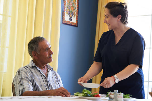 istock Professional helpful caregiver and a senior man during home visit 1185758896