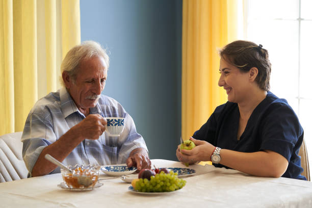 istock Professional helpful caregiver and a senior man during home visit 1185758915